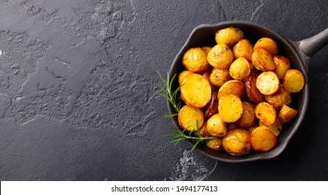 Roasted Baby Potatoes In Iron Skillet. Dark Grey Background. Copy Space. Top View.