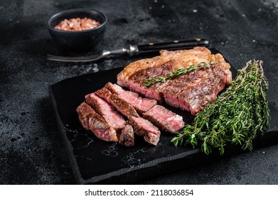 Roasted bbq Chuck Roll beef steaks with herbs. Black background. Top view