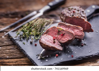 Roasted Beef steak with salt pepper thyme on rustic wooden table. - Powered by Shutterstock