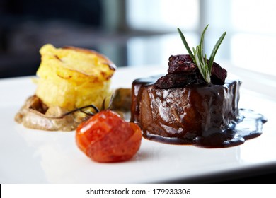 Roasted beef tenderloin with herb-potato muffin, mushroom ragout, baked tomatoes and rosemary-currant sauce