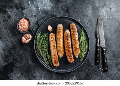 Roasted Bockwurst pork meat sausages in a plate. Black background. Top view