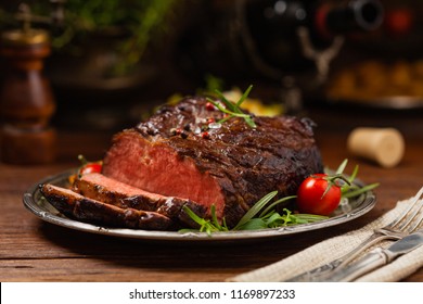 Roasted brisket. Rustic style, natural wooden background. Dark style. Front view. 