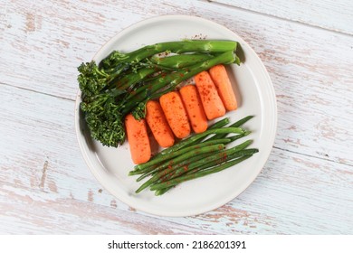 Roasted Broccoli And Carrot With Bean  On The Plate, Isolated White Wooden Background.