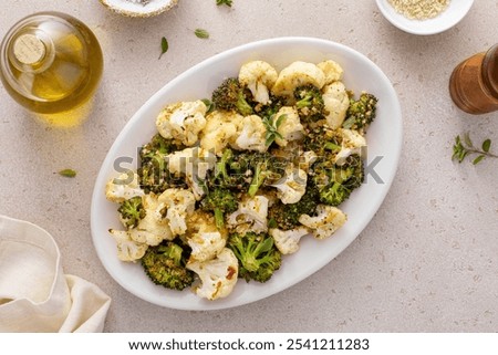 Roasted broccoli and cauliflower on a serving plate with herbs and spices, vegetarian side dish