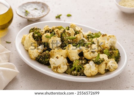 Roasted broccoli and cauliflower on a serving plate with herbs and spices, vegetarian side dish