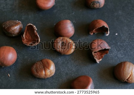 Roasted chestnuts with brown shells is isolated on black background in this seasonal nature.