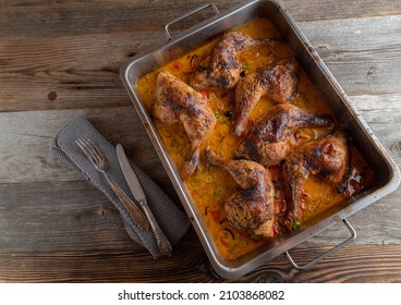 Roasted chicken legs in a delicious harissa cream sauce isolated on wooden table. Overhead view