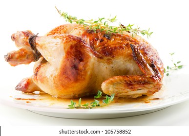 Roasted chicken on white plate with thyme