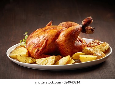 Roasted Chicken And Potatoes On White Plate
