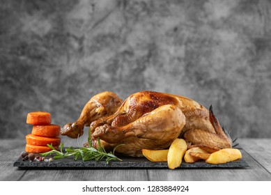 Roasted Chicken, Potatoes And Vegetables On Dark Plate. Side View.