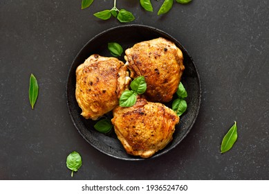 Roasted Chicken Thighs In Plate Over Dark Stone Background. Top View, Flat Lay