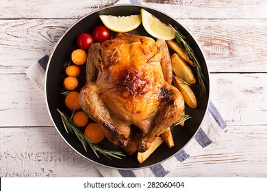 Roasted chicken and vegetables on the wooden table