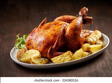 roasted chicken and vegetables on wooden table