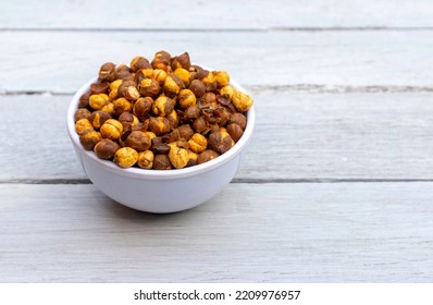 Roasted Chickpea  Or Garbanzo Bean Coated With Spices, Salt And Chili Powder In A Bowl Isolated White Wooden Background With Copy Space, Also Known As Bengal Gram Or Egyptian Pea