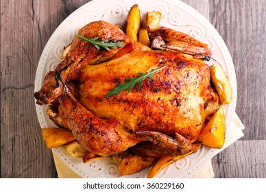 Roasted citrus chicken on plate with slices of orange