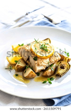 Roasted cod, codfish with baked potatoes and artichokes with lemon and herbs sauce