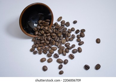 roasted coffee bean spilled out from a cup - Shutterstock ID 2206006709