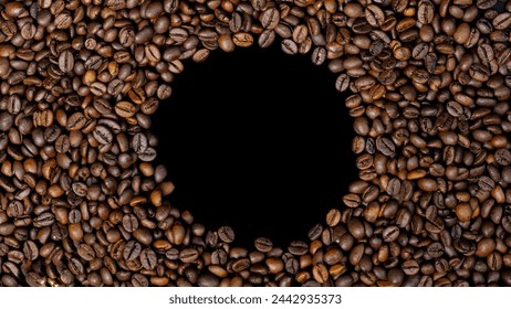 Roasted coffee beans with a circle shape in the middle on a black or dark background. Top view with copy space for your text - Powered by Shutterstock