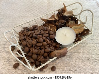 Roasted Coffee Beans And Dry Leaves And Candle In The Metal Wire Basket