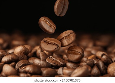 Roasted coffee beans falling on heap against dark background, closeup - Powered by Shutterstock