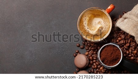 Roasted coffee beans, ground coffee in filter holder and espresso cup. Top view flat lay with copy space