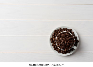 Roasted coffee beans inside white coffee cup