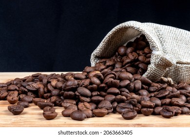 Roasted Coffee Beans And Little Jute Bag In Wooden Table In Brazil