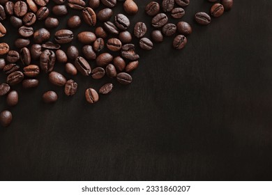 Roasted coffee beans on a wooden dark table, top view. Background of fragrant brown coffee beans scattered over the surface. Copy space - Powered by Shutterstock