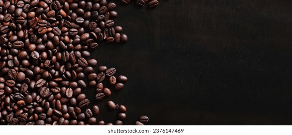 Roasted coffee beans on a wooden dark table, top view. Background of fragrant brown coffee beans scattered over the surface. copy space. Place for text - Powered by Shutterstock