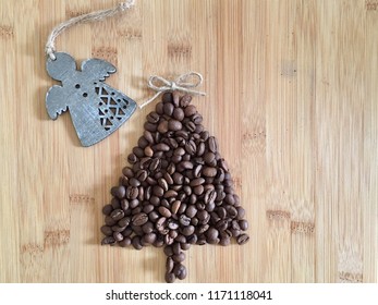 Roasted Coffee Beans Shaped Into Christmas Tree On Rustic Bamboo Wood Board, With Wood Cutout Angel, Twine Jute Bow As Tree Topper, Holiday Theme With Copy Space