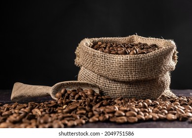 Roasted coffee beans with small sack and wooden scoop