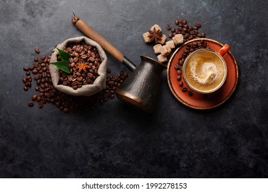 Roasted coffee beans, Turkish jezve, espresso coffee cup and brown sugar. Top view flat lay with copy space