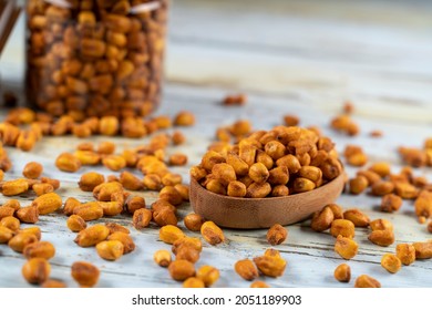 Roasted corn nuts in a glass jar and roasted corns in a wooden plate