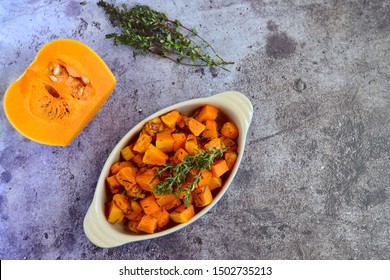 Roasted Cubed Butternut Squash With Thyme On Grey Background. Top View