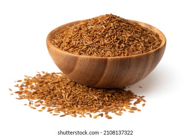 Roasted cumin seeds in the wooden spoon, isolated on the white background.