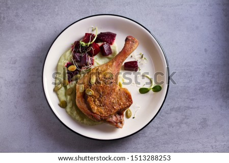 Roasted duck with celeriac puree and beetroot, sprinkled with pumpkin seeds. View from above, top studio shot
