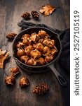 Roasted edible sweet chestnuts in iron pan on wooden table