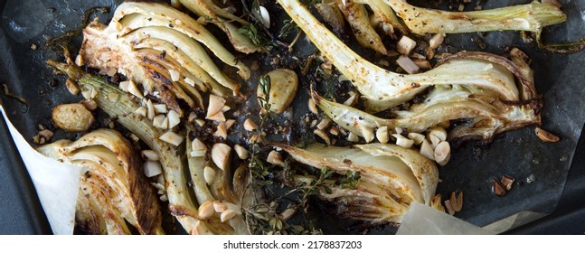 Roasted Fennel With Thyme And Almonds On A Baking Sheet