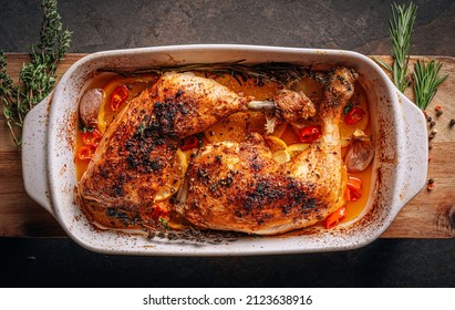 roasted fried turkey duck thighs, rubbed with spices and salt, on a baking sheet, with oranges, lemons, garlic, rosemary, thyme and olive oil. the concept of a healthy and tasty dinner for two.