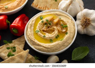 Roasted Garlic Hummus Topped With Olive Oil And Garlic Cloves