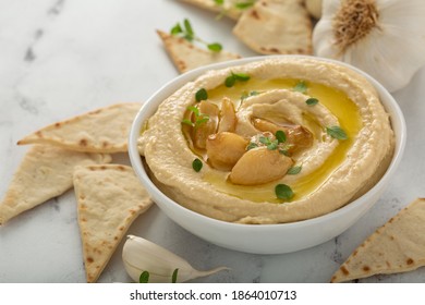 Roasted Garlic Hummus Topped With Olive Oil And Garlic Cloves