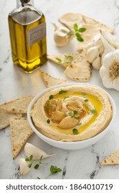 Roasted Garlic Hummus Topped With Olive Oil And Garlic Cloves