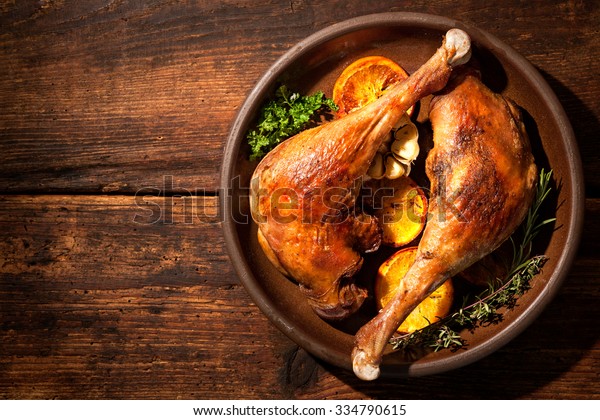 Roasted goose legs with oranges and spices. Cooking\
at Christmas time