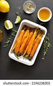 Roasted Honey Glazed Carrots In Baking Dish On Dark Background. Top View, Flat Lay