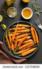 Roasted Honey Glazed Carrots On Plate Over Dark Stone Background. Top View, Flat Lay