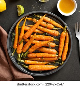 Roasted Honey Glazed Carrots On Plate Over Dark Stone Background. Top View, Flat Lay