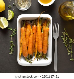 Roasted Honey Glazed Carrots In White Baking Dish On Dark Stone Background. Top View, Flat Lay