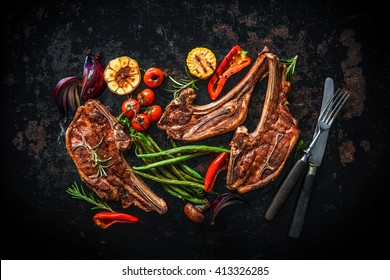 Roasted lamb meat with vegetables on dark background