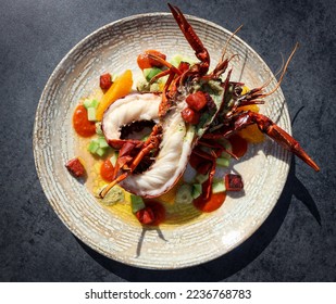Roasted Marron, lobster with diced salad. Caught in Denmark, western Australia. Black background on a light textured plate