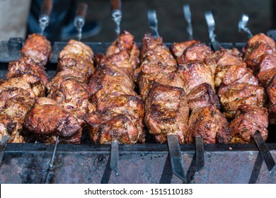 Roasted meat cooked at barbecue. Grilled kebab cooking on metal skewer. BBQ fresh beef meat chop slices. Traditional eastern dish, shish kebab. Grill on charcoal and flame, street food, Ukraine